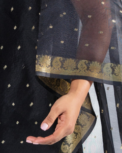 Woman showing the gold on the sleeves of a black summer wrap
